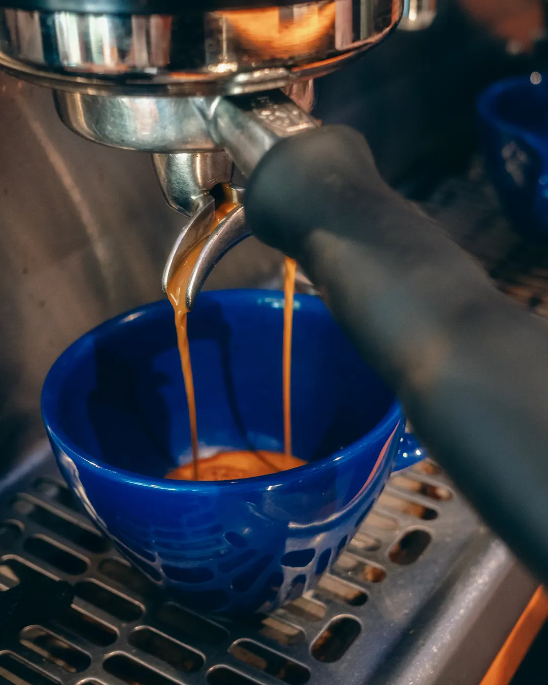 Espresso pouring into a blue cup on the machine at Warmondstraat